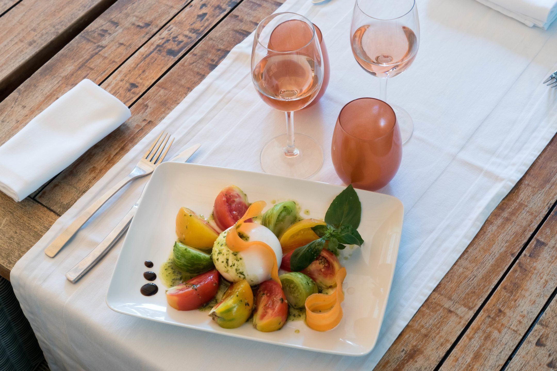 Burrata, tomates anciennes et pistou à l'huile d'olive, avec un verre de rosé