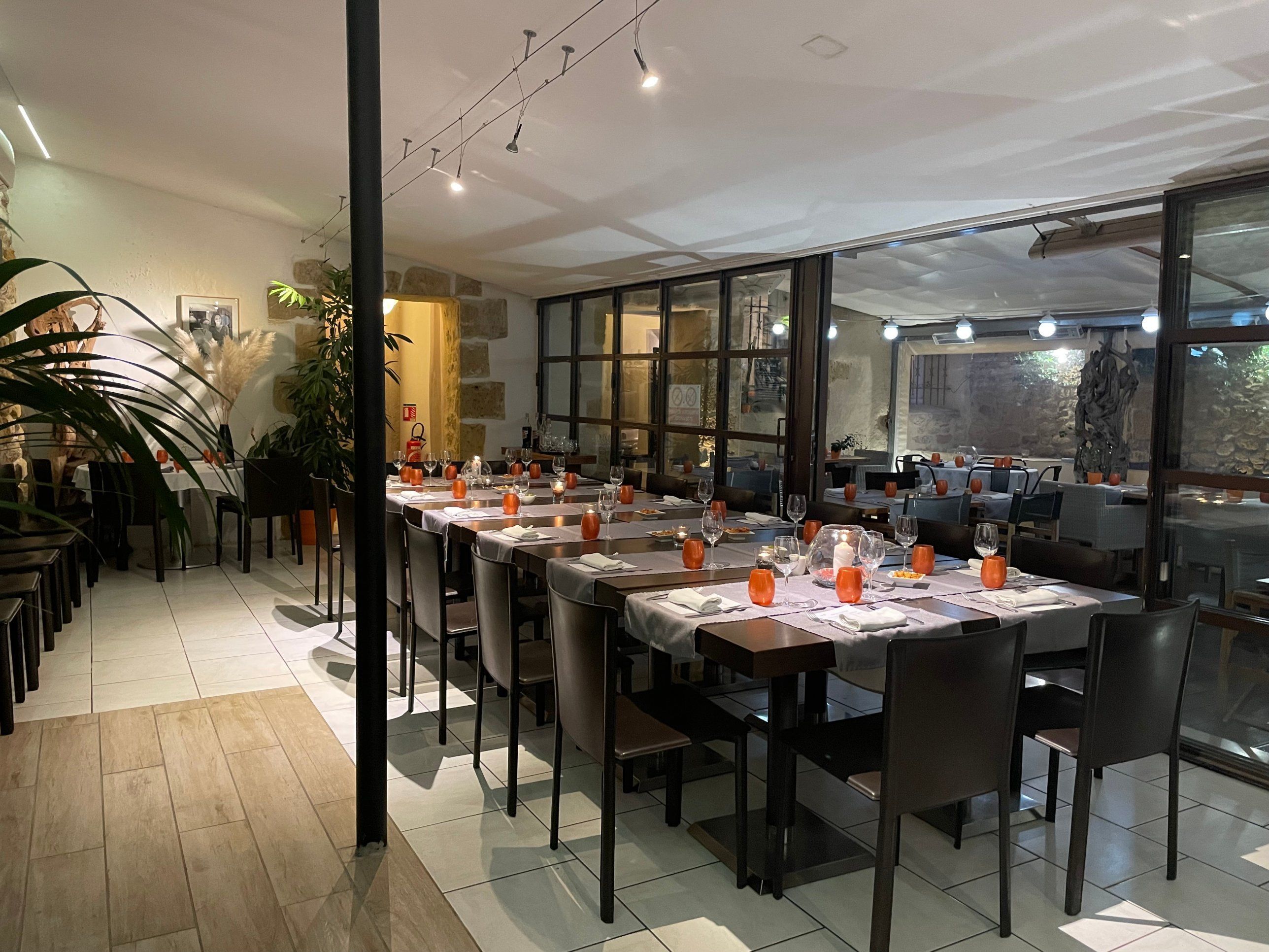 Une longue table dressée pour un repas de groupe, le soir